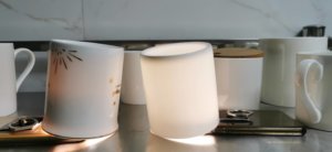 bone china mugs and porcelain mugs with torch on in light