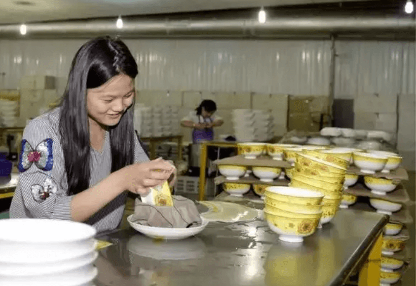 decal worker applying decal on bone china tableware
